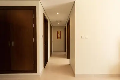 a hallway with a row of doors and a long corridor at Grand Stay Holiday Homes Rental in Dubai