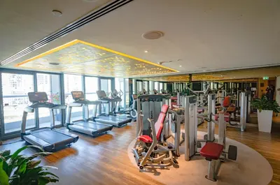 a gym with a bunch of treadms and cardio machines at Royal Club By RVHR, Paramount Tower B, Business Bay in Dubai