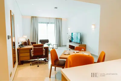 an office with orange chairs and desks in a room at HE Hotel Apartments in Dubai