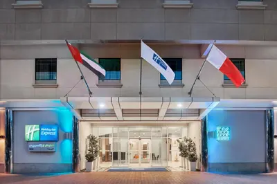 a building with three flags in front of it at Holiday Inn Express Dubai Safa Park by IHG in Dubai