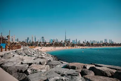 a beach with rocks and people on the beach at Holiday Inn Express Dubai, Jumeirah by IHG in Dubai
