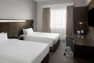 a hotel room with two beds and a desk at Holiday Inn Express Dubai, Jumeirah by IHG in Dubai