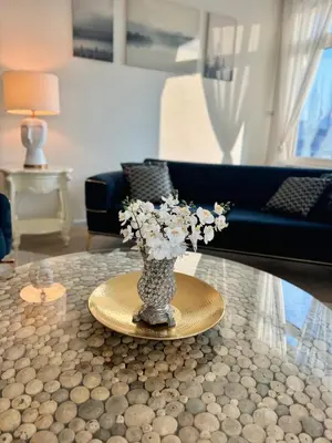 a vase with flowers on a table in a living room at Luxury - Beachfront - Spacious Shoreline residences - 5 star private beach resort in Dubai