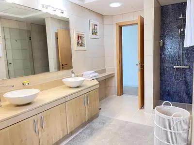 a bathroom with two sinks and a shower at Luxury - Beachfront - Spacious Shoreline residences - 5 star private beach resort in Dubai
