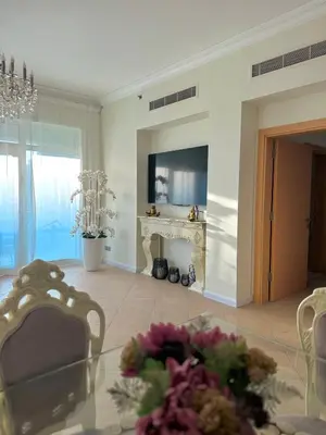 a living room with a fireplace and a table with flowers at Luxury - Beachfront - Spacious Shoreline residences - 5 star private beach resort in Dubai