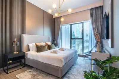 a bedroom with a bed and a large window at GuestReady - Gray Cloud Retreat - MBL Cluster in Dubai