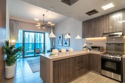 a kitchen with wooden cabinets and a stove top oven at GuestReady - Gray Cloud Retreat - MBL Cluster in Dubai