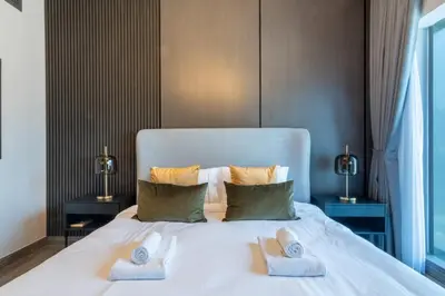 a bedroom with a white bed with two towels on it at GuestReady - Gray Cloud Retreat - MBL Cluster in Dubai