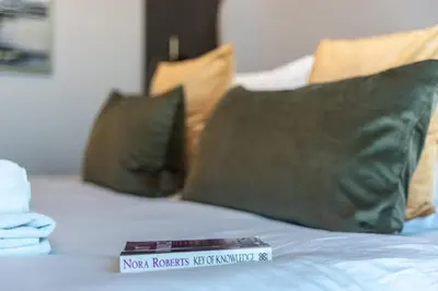 a book sitting on top of a bed with pillows at GuestReady - Gray Cloud Retreat - MBL Cluster in Dubai