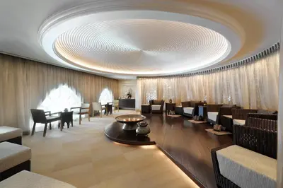 a lobby with chairs and tables and a large ceiling at Palace Downtown in Dubai