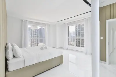 a white bedroom with a bed and two windows at Waterfront Luxury 3BR with maids room in JBR, Dubai in Dubai