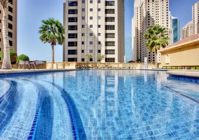 a large swimming pool in a city with tall buildings at Waterfront Luxury 3BR with maids room in JBR, Dubai in Dubai