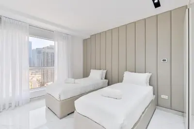 two beds in a room with a window at Waterfront Luxury 3BR with maids room in JBR, Dubai in Dubai