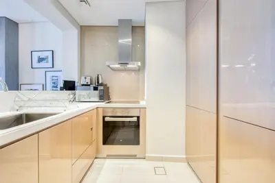 a kitchen with white counters and a sink at Maison Privee - Cool Dubai Apt next Burj Khalifa & Design District in Dubai
