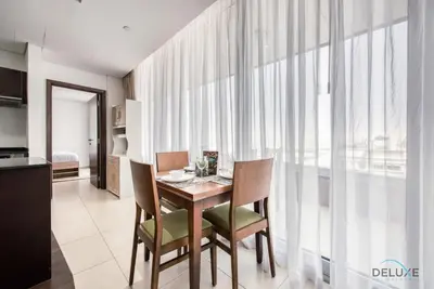 a dining room with a table and chairs in a kitchen at Homely 1BR at The Matrix Dubai Sports City by Deluxe Holiday Homes in Dubai