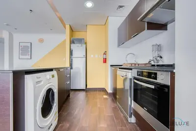 a kitchen with a washer and a dishwasher at Homely 1BR at The Matrix Dubai Sports City by Deluxe Holiday Homes in Dubai