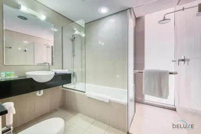 a bathroom with a toilet and a sink and a shower at Homely 1BR at The Matrix Dubai Sports City by Deluxe Holiday Homes in Dubai