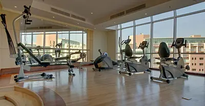 a gym with a bunch of exercise bikes in a room at Chelsea Gardens Hotel Apartment in Dubai