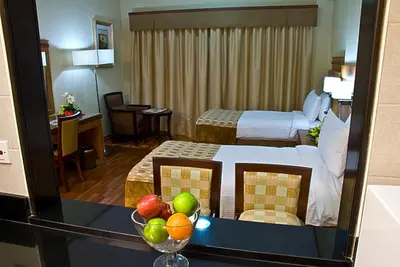 a hotel room with a bed and a bowl of fruit at Chelsea Gardens Hotel Apartment in Dubai