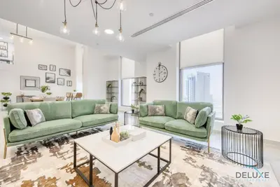 a living room with two green couches and a table at Outstanding 3BR at Sadaf 7 JBR by Deluxe Holiday Homes in Dubai