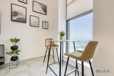 a dining room with a glass table and two chairs at Outstanding 3BR at Sadaf 7 JBR by Deluxe Holiday Homes in Dubai