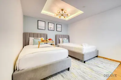 a bedroom with two beds and a chandelier at Outstanding 3BR at Sadaf 7 JBR by Deluxe Holiday Homes in Dubai