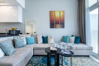 a living room with a couch with blue pillows at The Smart Concierge - Damac 108 in Dubai