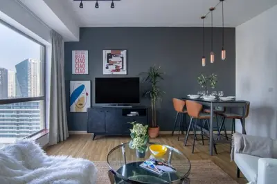 a living room with a couch and a table with a television at The Smart Concierge - Bahar 6 in Dubai