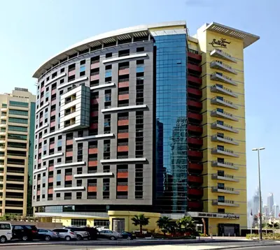 a tall building with cars parked in front of it at Belle Vue Building in Dubai