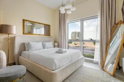 a bedroom with a bed and a large window at GuestReady Holiday Homes - A Rose in the Sky in Dubai