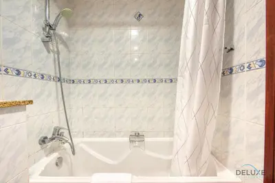 a bathroom with a tub and a shower and a sink at Calm Studio at Lake View Tower JLT by Deluxe Holiday Homes in Dubai