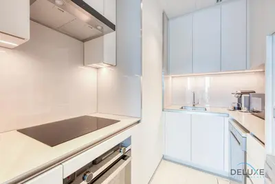 a kitchen with white cabinets and a sink at Exquisite 1BR at The Address Residences in JBR by Deluxe Holiday Homes in Dubai
