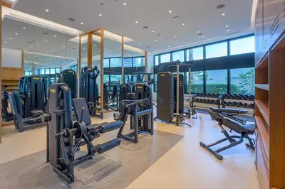 a gym with rows of tread machines and mirrors at Exquisite 1BR at The Address Residences in JBR by Deluxe Holiday Homes in Dubai