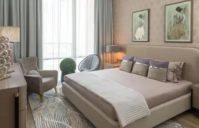 a bedroom with a large bed and a chair at Royal Club By RVHR, Noora Tower, Al Habtoor City, Business Bay in Dubai