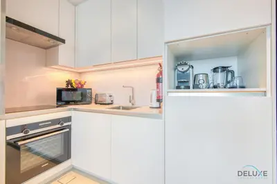 a kitchen with white cabinets and a sink at Classy 1BR at The Address Residences in JBR by Deluxe Holiday Homes in Dubai