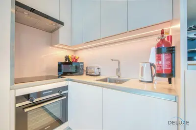 a kitchen with white cabinets and a sink at Classy 1BR at The Address Residences in JBR by Deluxe Holiday Homes in Dubai
