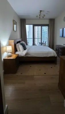 a bedroom with a large bed and a large window at Cozy 2 BR apt Golf Tower Greens, stunning Golf views in Dubai