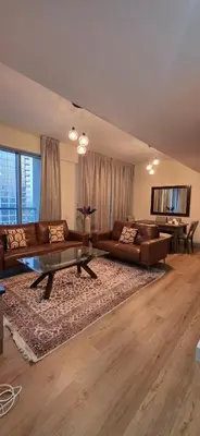 a large living room with couches and a table at Cozy 2 BR apt Golf Tower Greens, stunning Golf views in Dubai