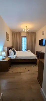 a bedroom with a large bed and a window at Cozy 2 BR apt Golf Tower Greens, stunning Golf views in Dubai