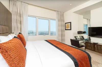 a bedroom with a large bed and a large window at Royal Club By RVHR, Bonnington Residential Tower - JLT in Dubai