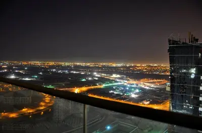 a view of a city at night with a tall building at Royal Club By RVHR, Bonnington Residential Tower - JLT in Dubai