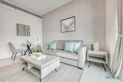 a living room with a couch and a table at Modern 1BR Oasis in Prime Location, Book Now by Deluxe Holiday Homes in Dubai
