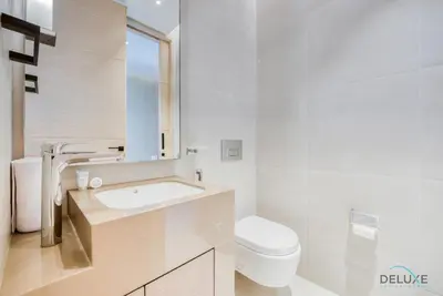 a white bathroom with a sink and a toilet at Modern 1BR Oasis in Prime Location, Book Now by Deluxe Holiday Homes in Dubai