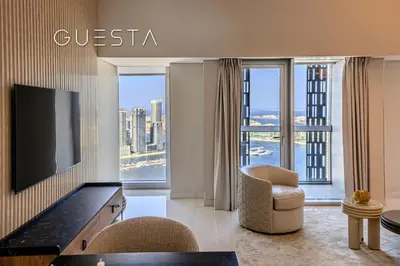 a living room with a television and a couch and a chair at Cayan Tower, Dubai Marina in Dubai