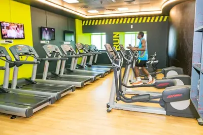 a woman running on treadles in a gym at Luxury Kings Palace Private Room with Shared Kitchen Next To Barasti Beach in Dubai