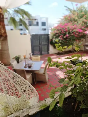 a patio with a table and chairs and flowers at Jumeirah Beach Villa in Dubai