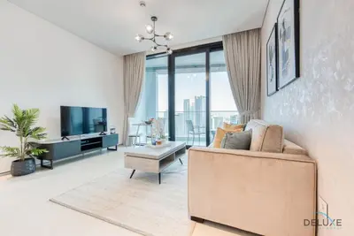 a living room with a couch and a tv at Posh 1BR at The Address Residences in JBR by Deluxe Holiday Homes in Dubai