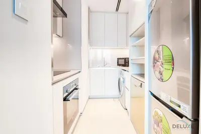 a kitchen with white cabinets and a narrow hallway at Posh 1BR at The Address Residences in JBR by Deluxe Holiday Homes in Dubai