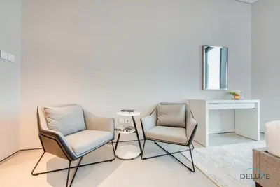 a living room with two chairs and a table at Posh 1BR at The Address Residences in JBR by Deluxe Holiday Homes in Dubai