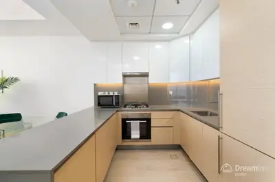 a kitchen with white cabinets and a stove top oven at Dream Inn Apartments - Mina by Azizi in Dubai